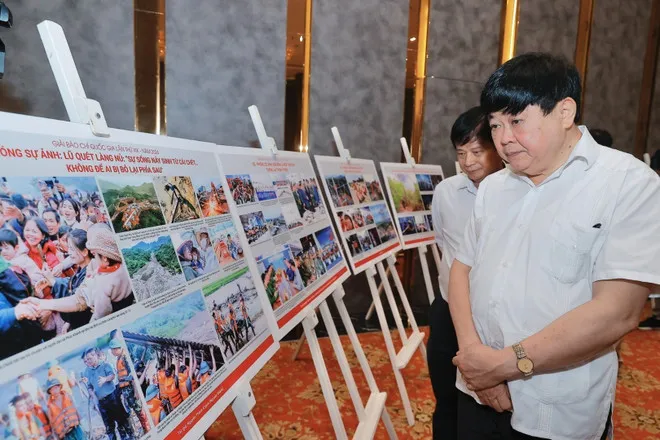 Thành viên Hội đồng chung khảo Giải báo chí Quốc gia xem, thảo luận về các tác phẩm ảnh lọt vào vòng chung khảo. (Ảnh: Minh Quyết/TTXVN)