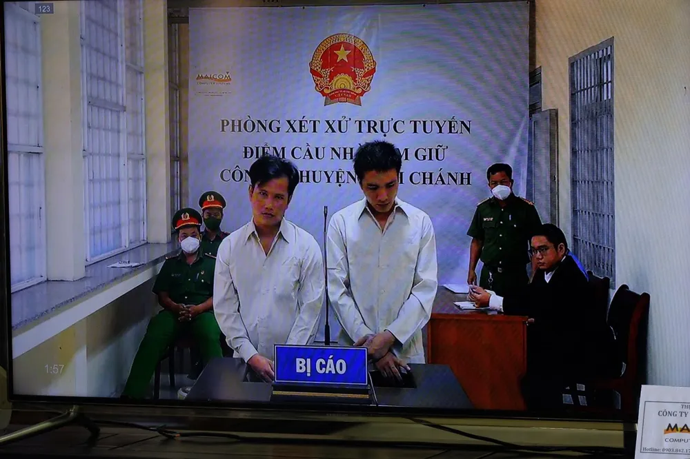 Bị cáo Bửu và Xuyên tại điểm cầu giam giữ công an huyện Bình Chánh. Ảnh: NT Bị cáo Bửu và Xuyên tại điểm cầu giam giữ công an huyện Bình Chánh. Ảnh: NT