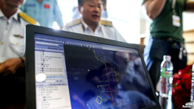 Các nhân viên xem đường bay của máy bay MH370 trên màn hình để chuẩn bị cho việc tìm kiếm.