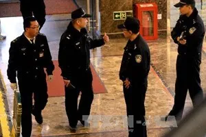 Cảnh sát Trung Quốc gác tại cửa Khách sạn Lido, nơi thân nhân các hành khách trên máy bay mất tích lưu trú trong khi chờ tin tức vụ việc, ở Bắc Kinh (Trung Quốc) ngày 17/3. (Ảnh: AFP/TTXVN)