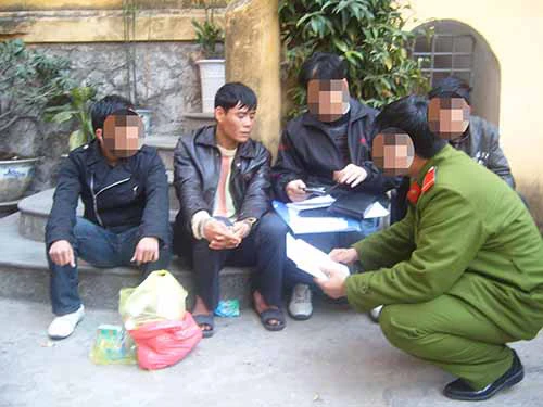 Dư Kim Dũng (Dũng “Tình”, trùm ma túy đất cảngngồi giữa bị còng tay) lúc bị bắt. Dư Kim Dũng (Dũng tình, ngồi giữa bị còng tay) lúc bị bắt