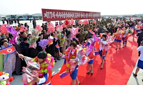 Đoàn vận động viên Triều Tiên choàng quốc kỳ lên người trong lễ đón tiếp tại sân bay Bình Nhưỡng.