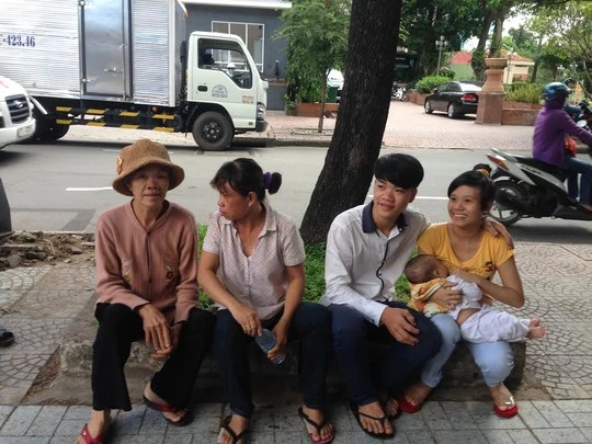 Mẹ chồng T. (bìa trái) sợ cháu bị nắng nên đón xe con đưa dâu tham dự phiên tòa