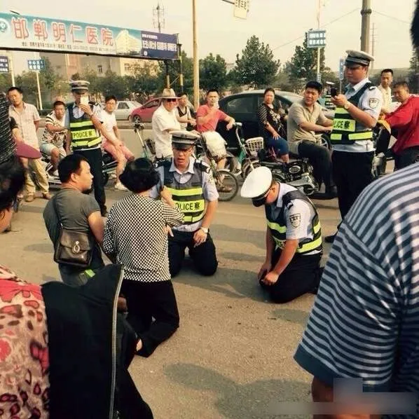 Cảnh sát giao thông quỳ xuống đất để giải thích cho dân ảnh 1