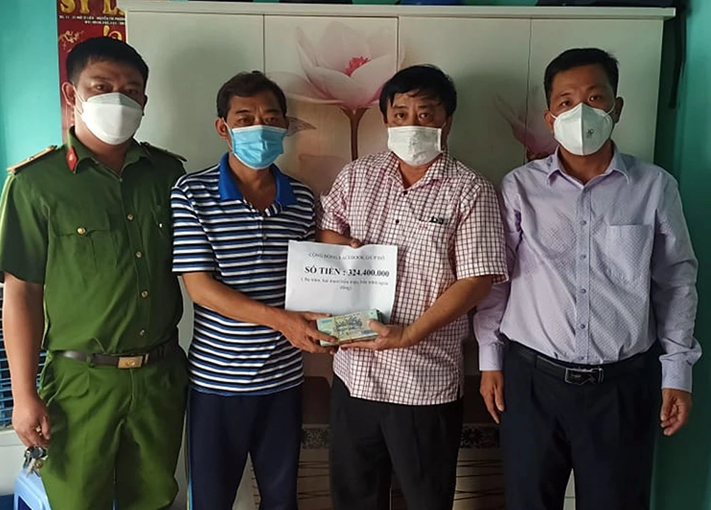 Nhà báo Phương Nam (thứ hai từ phải qua) trao tiền hỗ trợ của cộng đồng cho gia đình bé Linh. Trong đó, số tiền 220 triệu dành lập một sổ tiết kiệm cho bé Linh để sau này nó có vốn làm ăn, 100 triệu đồng dùng để xây lại căn nhà đã xuống cấp và trao 6,4 triệu còn lại cho gia đình.