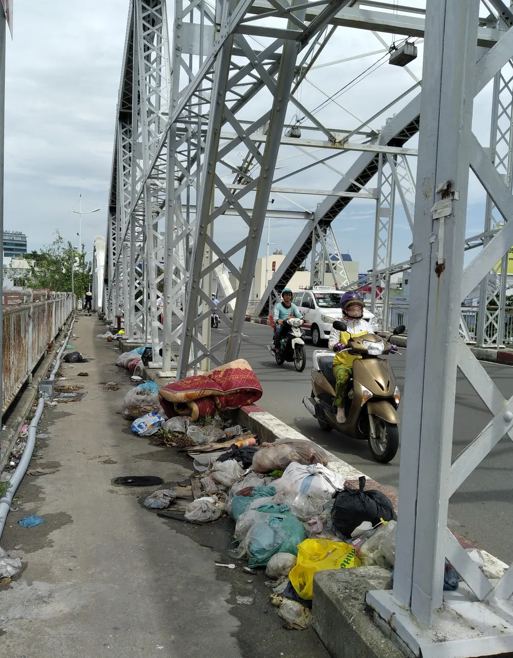 Rác thải vứt bỏ bừa bãi trên cầu Tân Thuận 1, phường Tân Thuận Tây, quận 7. Ảnh: THIÊN THẢO