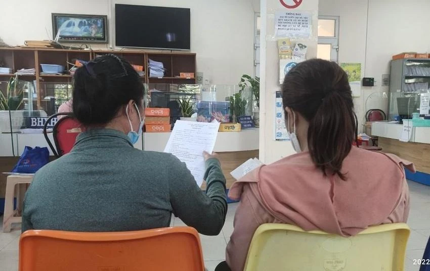 Người dân tại TP.HCM đang xem lại giấy tờ trước khi nộp hồ sơ nhận BHXH một lần. Ảnh: NGUYỄN HIỀN