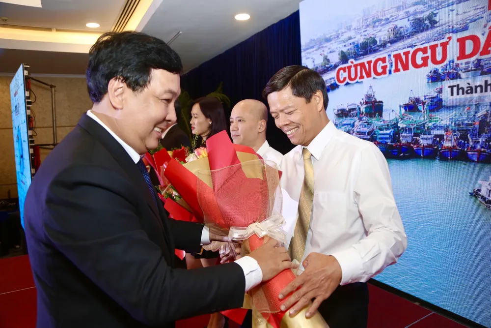 Phó Tổng biên tập báo Pháp Luật TP.HCM Nguyễn Thái Bình, Trưởng ban tổ chức chương trình “Cùng ngư dân thắp sáng đèn trên biển” trao hoa cảm ơn các nhà tài trợ đồng hành cùng chương trình. Ảnh: HOÀNG GIANG