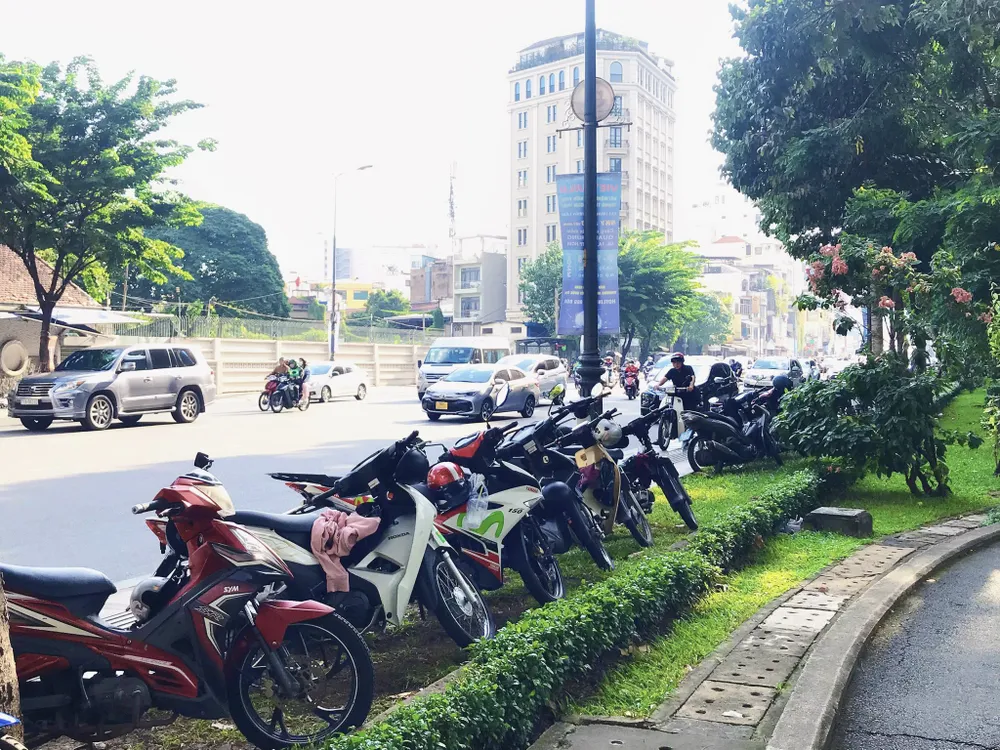 Công viên Hoàng Văn Thụ (quận Tân Bình) không có bãi giữ xe. Khi vào công viên, người dân tự để trên xe trên vỉa hè khóa lại và tự trông. Ảnh: TRẦN MINH bai giu xe.jpg