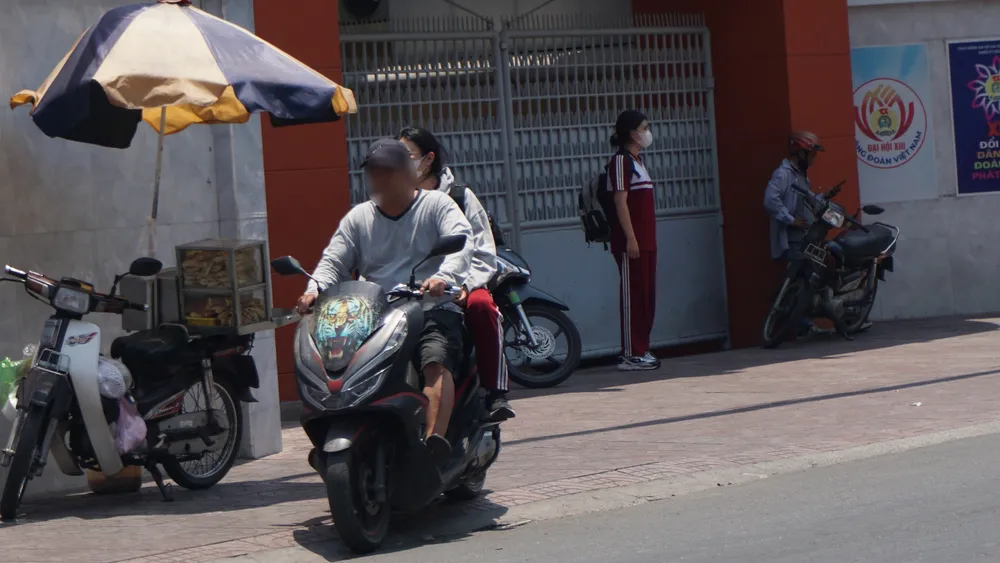 Phụ huynh đến đón học sinh không đội mũ bảo hiểm. hoc-sinh_h3.JPG