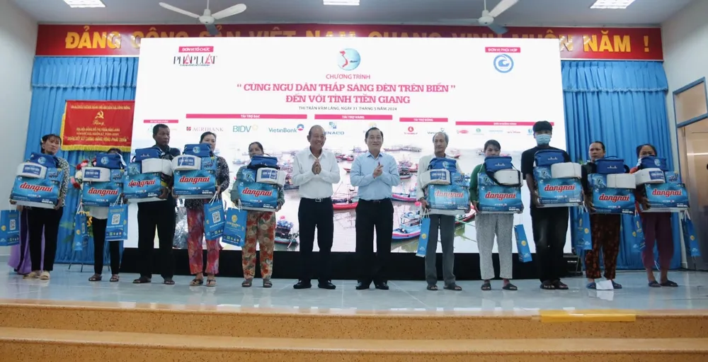 Ông Trương Hòa Bình, nguyên Ủy viên Bộ Chính trị, nguyên Phó Thủ tướng thường trực Chính phủ cùng ông Nguyễn Văn Vĩnh, Phó Bí thư Tỉnh ủy, Chủ tịch UBND tỉnh Tiền Giang trao quà cho ngư dân. Anh-sang-den_4.jpg