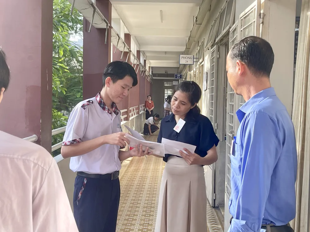 Tại điểm thi trường THCS Phạm Văn Chiêu, quận Gò Vấp các thầy cô giám thị bắt đầu điểm danh, kiểm tra thông tin thí sinh trước giờ phát đề thi. Đa số các em tại điểm thi này thực hiện đúng quy tắc của kỳ thi không đem theo bất kỳ vật dụng nào không đúng với quy định. Ảnh: TRẦN MINH thi vào lớp 10 6-6-8.jpg