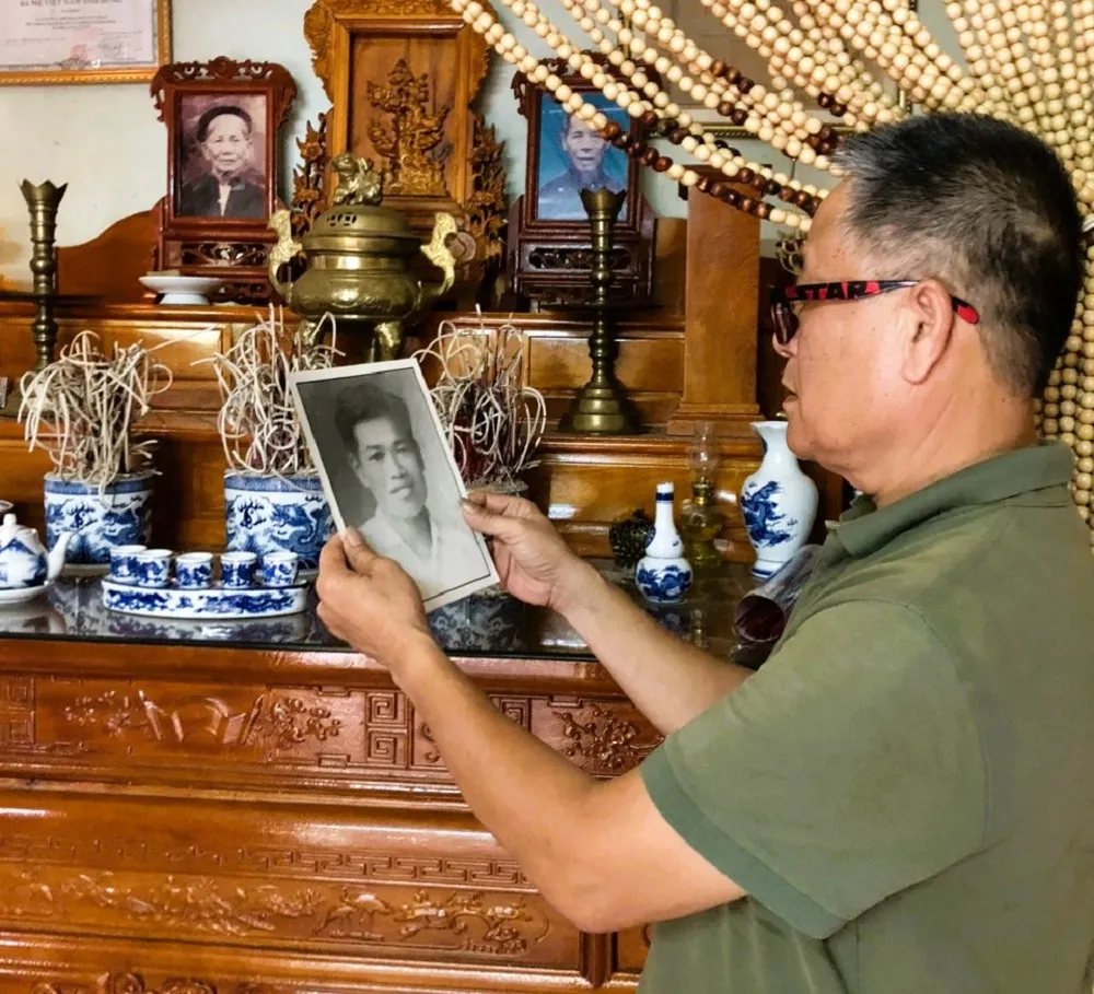 Ông Nguyễn Công Ninh bên bức ảnh của bố mình. Ảnh: VT. con-liet-si.jpg