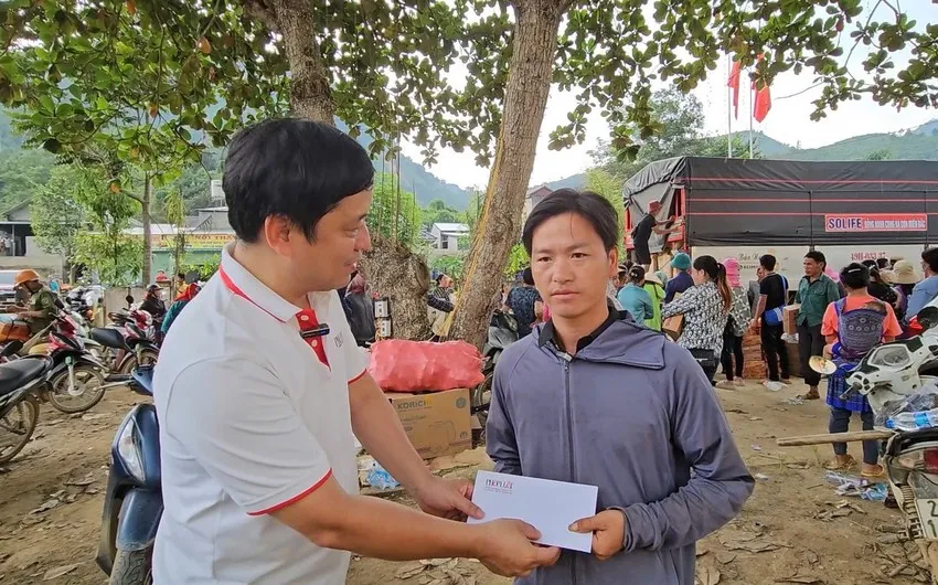Đại diện báo Pháp Luật TP.HCM trao gửi tấm lòng của bạn đọc đến trưởng thôn Kho Vàng Ma Seo Chứ. Ảnh: NGUYỄN VỮNG Kho Vang.jpg