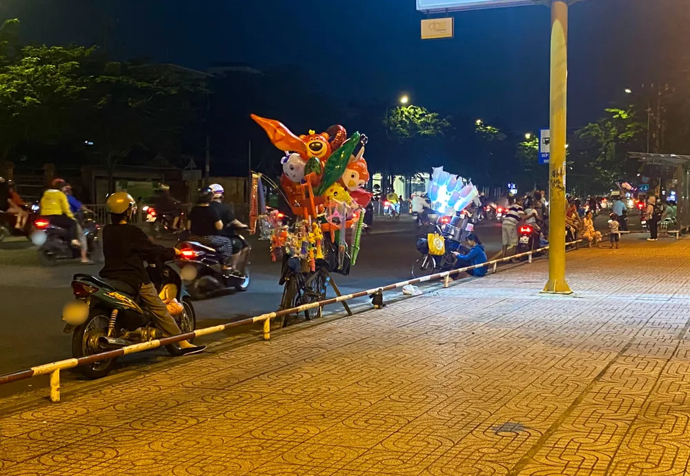Xe bán đồ chơi, kẹo bông gòn tại một điểm khác của công viên, khu vực đông đúc xe cộ qua lại Ảnh TUYẾT NHUNG.jpg