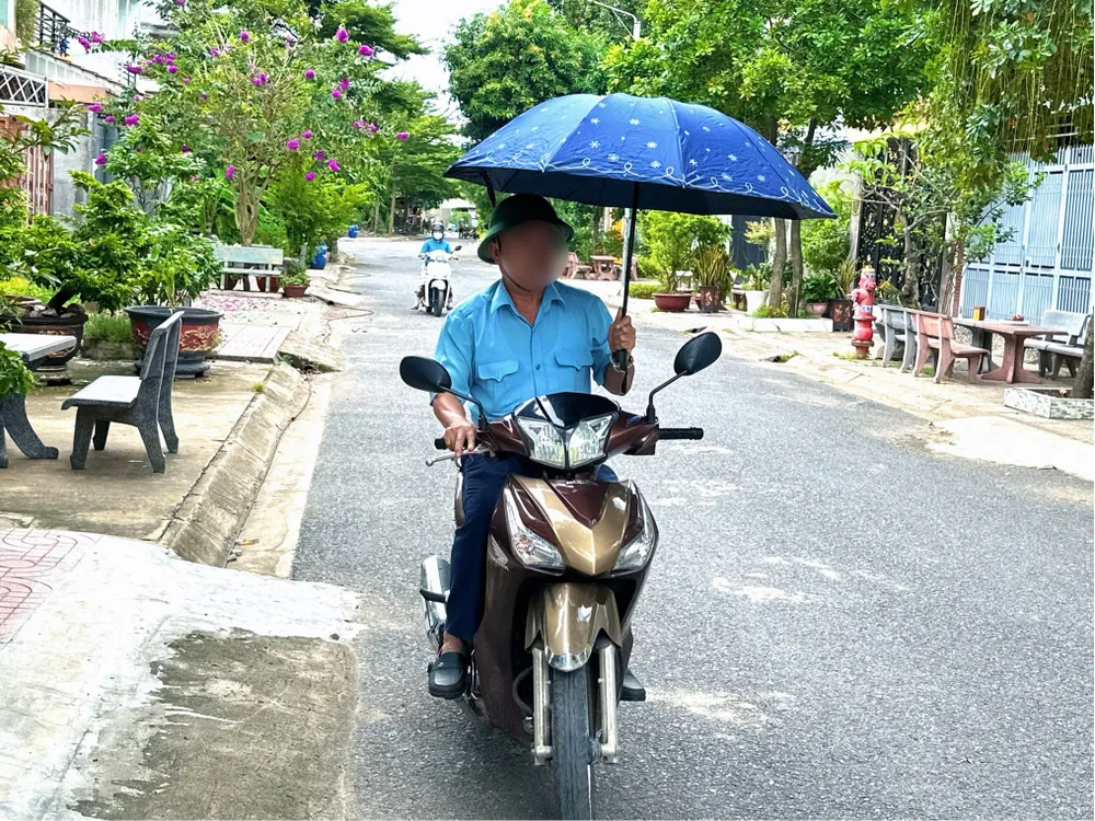 Phạt tiền từ 800.000 đến 1.000.000 đồng đối với hành vi sử dụng ô (dù) khi chạy xe máy. Ảnh: THẢO HIỀN Sử dụng ô (dù) khi chạy xe máy