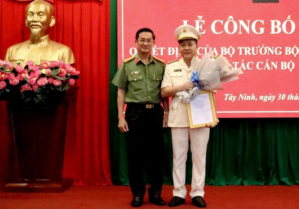 Giám đốc Công an tỉnh Tây Ninh Nguyễn Văn Trãi tặng hoa chúc mừng tân phó giám đốc công an tỉnh. Ảnh: CA