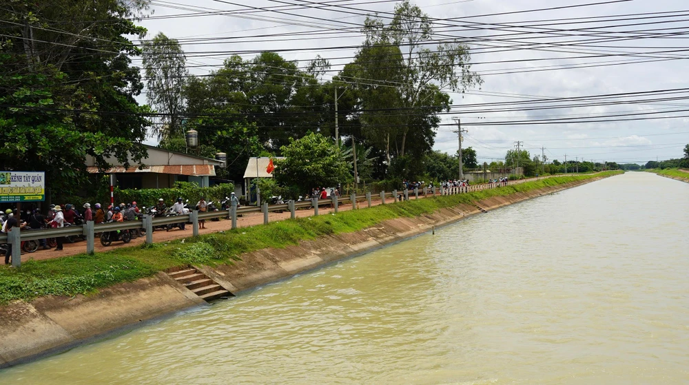Nhiều người dân địa phương hỗ trợ lực lượng cứu hộ tìm kiếm thi thể ba mẹ con chị Q. Ảnh TT