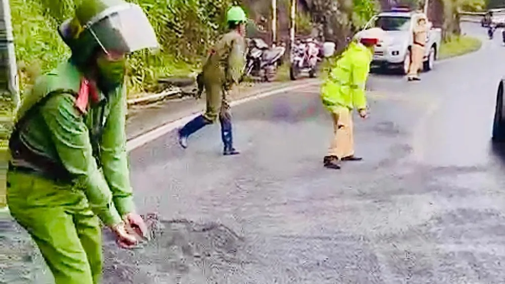 CSGT phải dùng cát và đá mi rải ra đường để chống trơn trượt. Ảnh VT