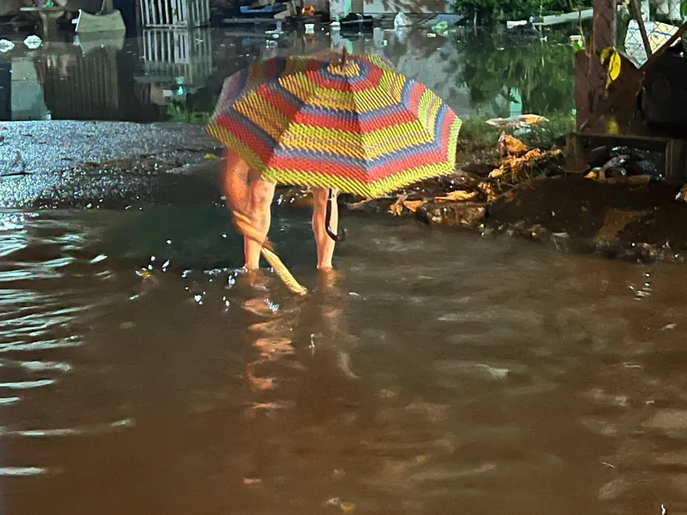 Người dân đội mưa ra khơi cống để thoát nước. Ảnh VÕ TÙNG