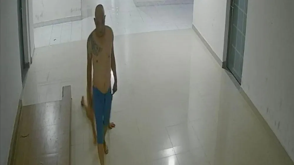 Luân &quot;Chùa&quot; dùng thắt lưng quấn cổ, dắt con đi trong hành lang. Ảnh: Cắt từ clip