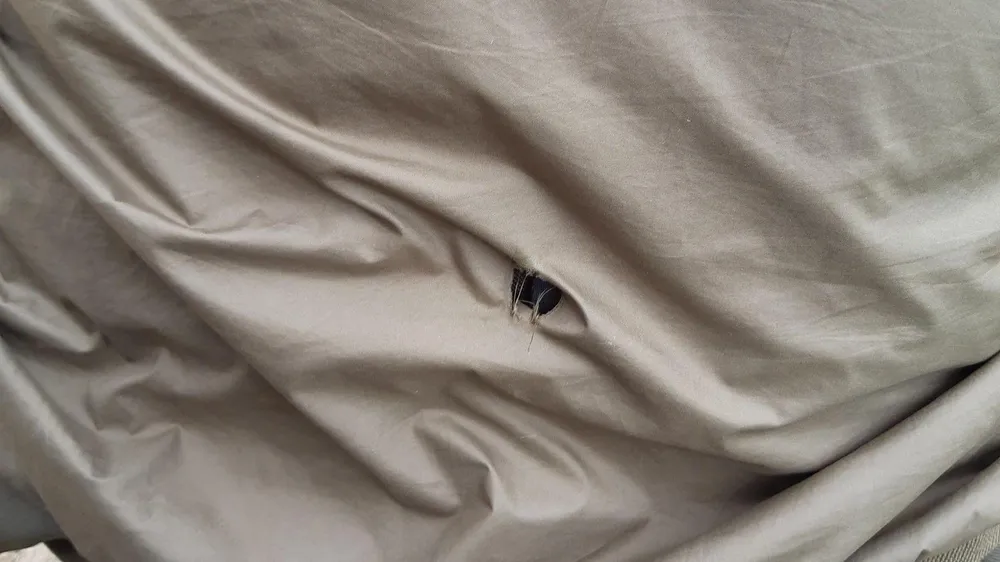 Viên đạn xuyên thủng áo khoác cán bộ bảo vệ rừng. Ảnh: VT Viên đạn xuyên thủng áo khoác cán bộ bảo vệ rừng. Ảnh: VT