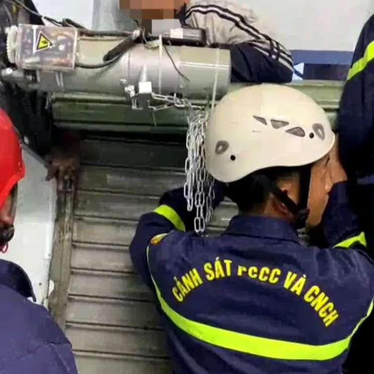 Lực lượng chức năng phải phá cửa để đưa tay cháu bé ra ngoài. Ảnh: LT Lực lượng chức năng phải phá cửa để đưa tay cháu bé ra ngoài. Ảnh: LT