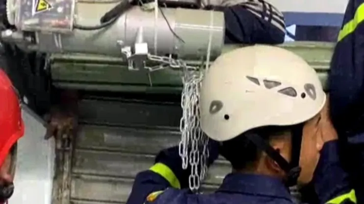 Vị trí tay trái của cháu bị kẹt gần bánh răng của cửa cuốn. Ảnh: LT Vị trí tay trái của cháu bị kẹt gần bánh răng của cửa cuốn. Ảnh: LT