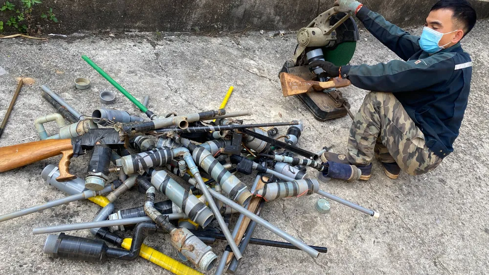 Cắt huỷ các linh kiện lắp ráp súng tự chế. Ảnh: CA