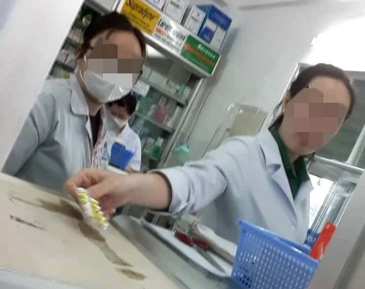 Nhân viên BV quận 4 không đeo khẩu trang khi bán thuốc cho người bệnh. Ảnh: TRẦN NGỌC