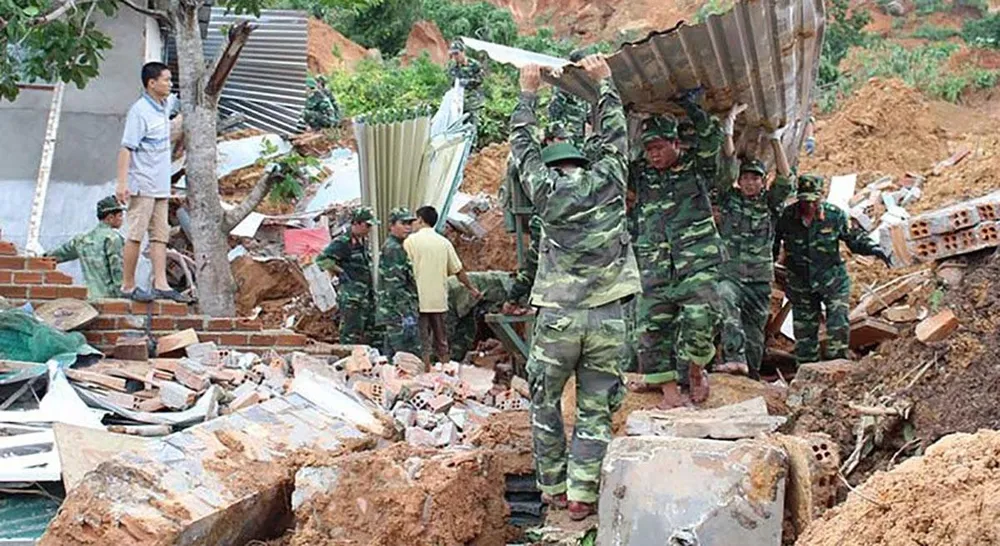 Lực lượng chức năng đang giúp người dân san dọn lại nhà cửa, đất đá sau vụ sạt lở núi kinh hoàng năm 2016. Ảnh: T.LỘC