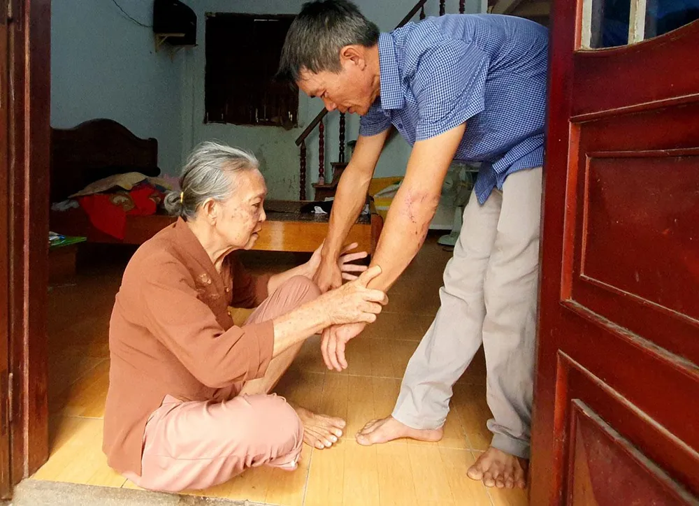 Ông Nguyễn Đăng Đình Hoàng chăm sóc mẹ trong căn nhà trọ. Ảnh: H.HẢI