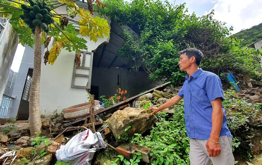 Ông Hoàng trước căn nhà của mình sau bốn năm xảy ra vụ sạt lở núi.