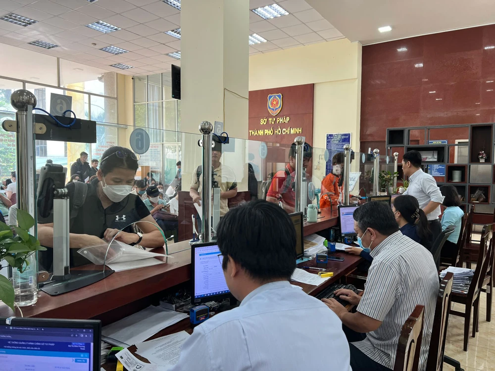 Người dân thực hiện thủ tục hành chính tại bộ phận một cửa Sở Tư pháp TP.HCM. Ảnh: HỮU ĐĂNG