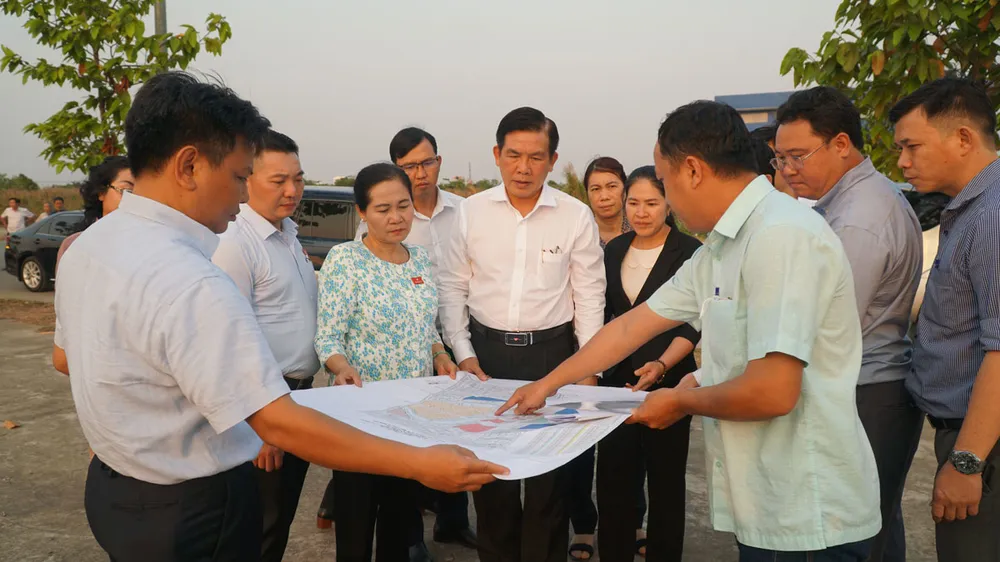 Ông Lương Minh Phúc (áo trắng giữa ảnh), Giám đốc Ban quản lý dự án đầu tư xây dựng các công trình giao thông TP và bà Nguyễn Thị Lệ , Chủ tịch HĐND TP (áo hoa), khảo sát tuyến đường vành đai 3 TP.HCM. Ảnh: NGUYỄN TIẾN