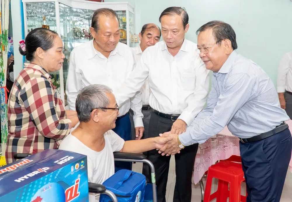 Ông Trương Hòa Bình, Chủ tịch danh dự của chương trình (thứ hai từ trái qua); Chủ tịch UBND tỉnh Bà Rịa-Vũng Tàu Nguyễn Văn Thọ và ông Mai Ngọc Phước (bìa phải), Trưởng Ban chỉ đạo chương trình, đến thăm, tặng quà gia đình ông Châu Minh Hoàng ở ấp Tân Phước, bị tai nạn lao động khi đi biển. Ảnh: MẠNH THẮNG