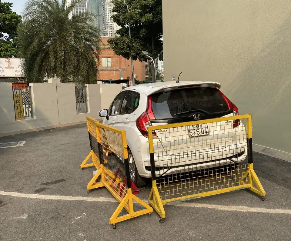 Xe của anh Sơn bị quây rào, khóa bánh. Ảnh: TỰ SANG