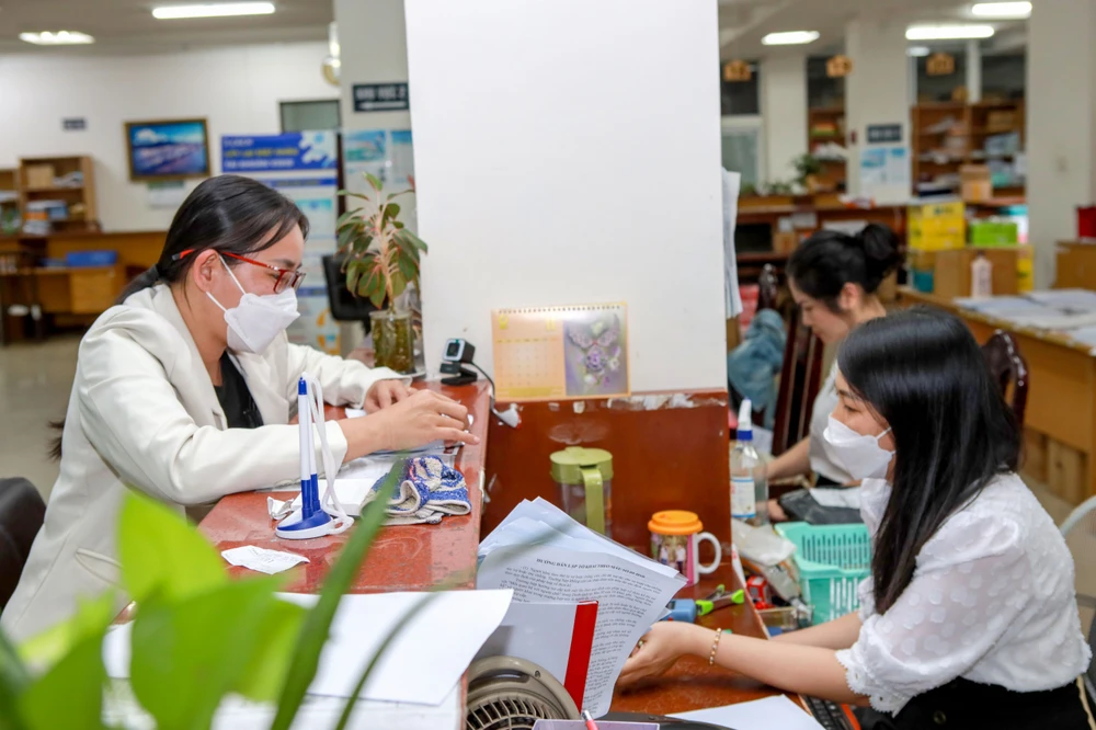 Người lao động đến BHXH TP.HCM liên hệ làm việc liên quan đến các thủ tục BHXH, BHYT. Ảnh: NGUYỆT NHI tien luong dong bhxh hang thang.jpg