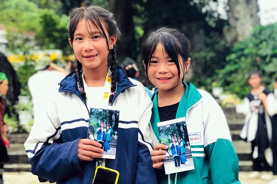 Trẻ vùng cao hạnh phúc nhận ảnh tặng từ anh Nguyễn Quang Toại. Ảnh: NVCC