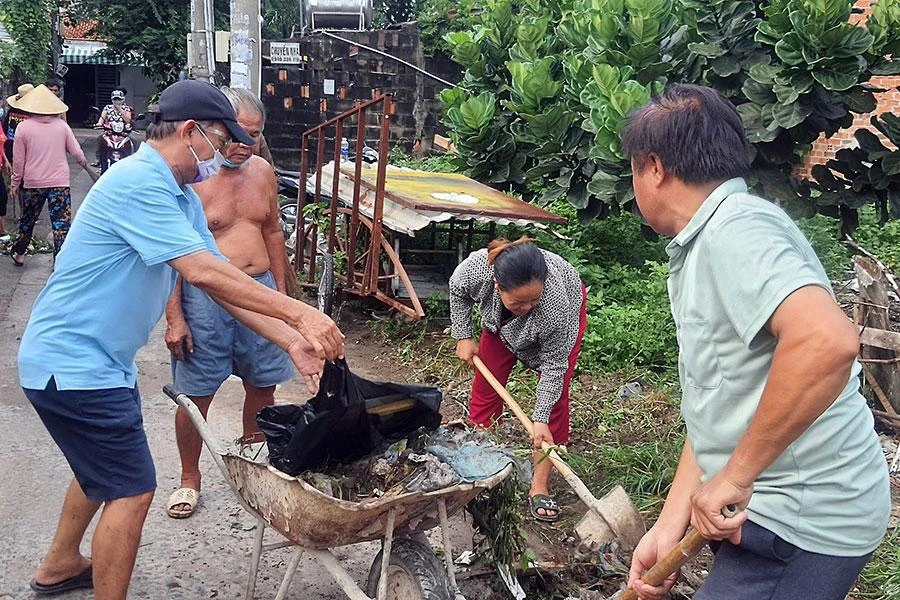 Người dân đang vệ sinh khu vực xung quanh nơi mình sinh sống để phòng chống dịch sốt xuất huyết. Ảnh: NH