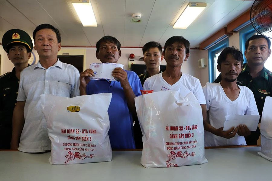 Lực lượng chức năng tặng quà cho các ngư dân thoát nạn. Ảnh: HUỲNH HẢI