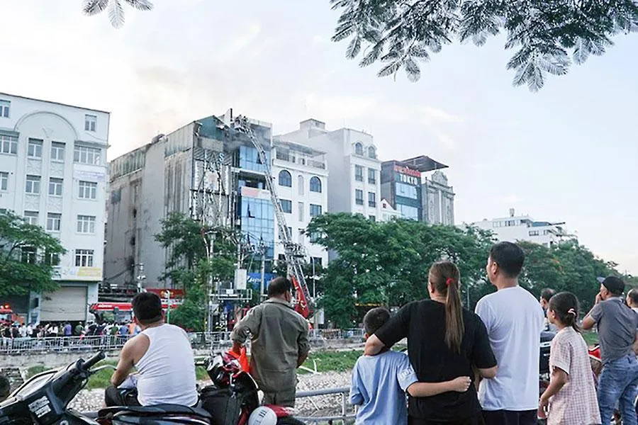 Sau 5 giờ đồng hồ, khói vẫn bốc lên trên tầng cao của quán karaoke ở quận Cầu Giấy, Hà Nội. Ảnh: P.HÙNG Sau 5 giờ đồng hồ, khói vẫn bốc lên trên tầng cao của quán karaoke ở quận Cầu Giấy, Hà Nội. Ảnh: P.HÙNG