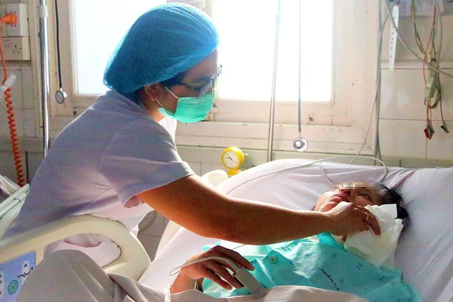 Chị Nguyễn Thị Kiều Mỹ, điều dưỡng CKI Khoa nhiễm Việt - Anh (BV Bệnh nhiệt đới), đang chăm sóc bệnh nhân. Ảnh: THẢO PHƯƠNG