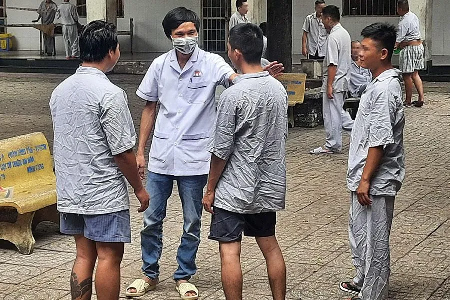 Điều dưỡng Mai Văn Huân đang trò chuyện thân mật với bệnh nhân tâm thần. Ảnh: TRẦN NGỌC