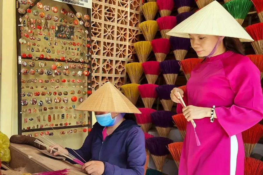 Du khách tham quan các gian hàng tại làng hương Thủy Xuân. Trong ảnh: Chị Đặng Thảo Nguyên đang làm hương.