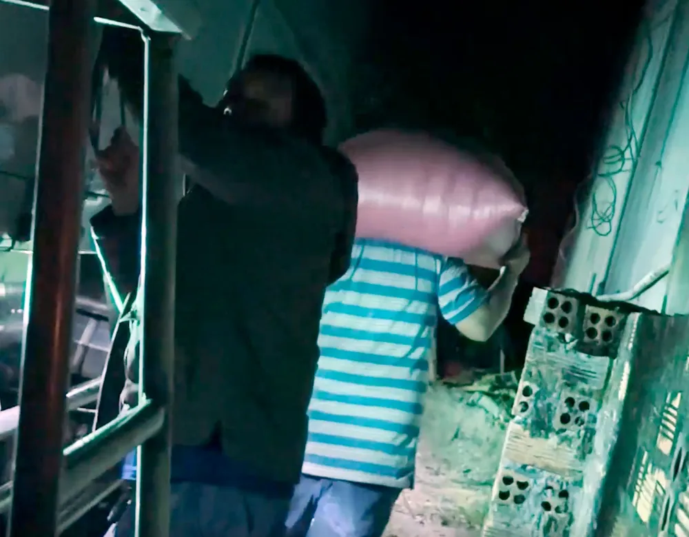 Ông Thoại phụ giúp tài xế lấy cà phê trên xe tải.