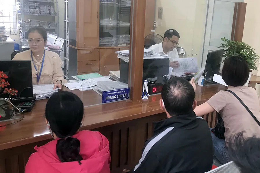 Cán bộ phường Hoàng Liệt, quận Hoàng Mai làm thủ tục hành chính cho người dân sáng 20-3. Ảnh: TRỌNG PHÚ