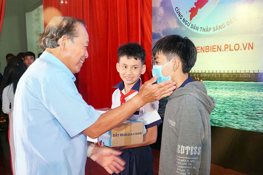 Ông Trương Hòa Bình, nguyên Phó Thủ tướng Thường trực - Chủ tịch Danh dự Chương trình, trao học bổng cho các em học sinh là con em ngư dân, vượt khó, học giỏi. Ảnh: BẢO PHƯƠNG