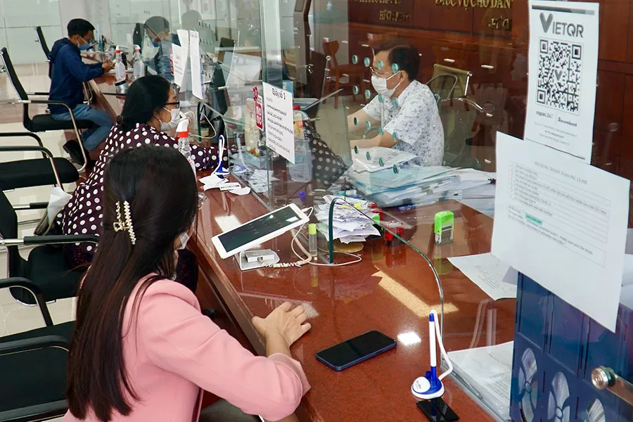 Người dân làm thủ tục hành chính tại bộ phận một cửa UBND quận 7. Ảnh: BẢO PHƯƠNG