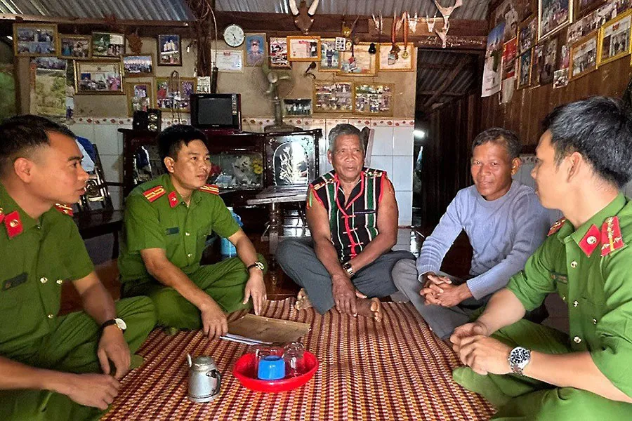Già làng Điểu Mpiăr (giữa) trò chuyện với cán bộ công an. Ảnh: VŨ LONG Già làng Điểu Mpiăr (giữa) trò chuyện với cán bộ công an. Ảnh: VŨ LONG